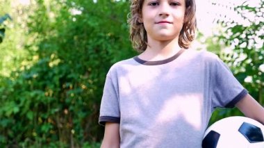 Gülümseyen ve kameraya, ağır çekim arıyorum futbol topu ile genç bir çocuk portresi