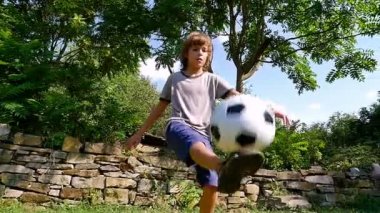 Ağır çekim genç çocuğun futbol topu eski bir evin avlusunda oynarken