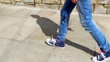 Genç çocukla şehirde yürüyüş bacaklar sadece kaykay