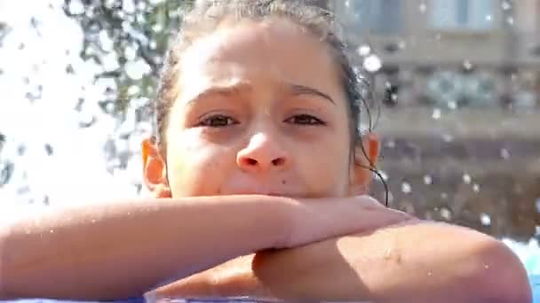 Élvezi a víz a medence szélén, egy aranyos kislány portréja — Stock videók