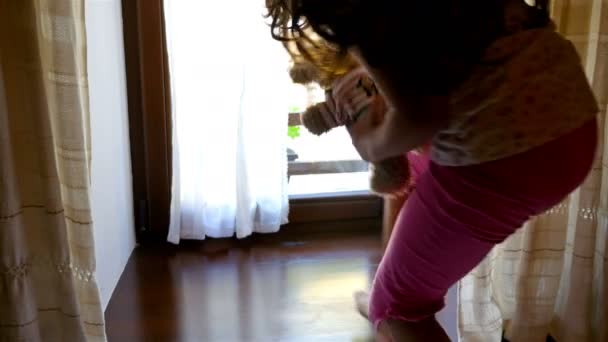 Onu ayı oyuncak ile eski bir ev cam kenarında oturan çaresiz yalnız küçük kız — Stok video