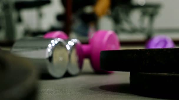 Man utbildning träna i gym, bumbbells i fronten — Stockvideo