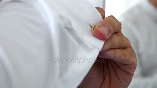 Man with white shirt and cufflinks putting on his wrist clock — Stock Video