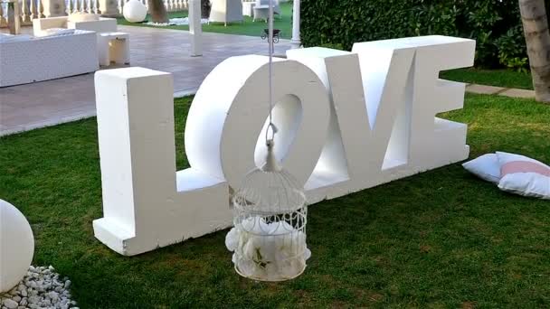 Jardín decorado para una fiesta de bodas, palabra grande Amor en el centro — Vídeos de Stock