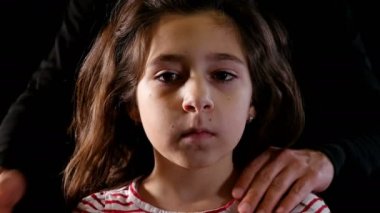 Aile içi şiddet kavramı. Siyah arka plan üzerine genç kız portresi. Adam ağzını elini koyarak.