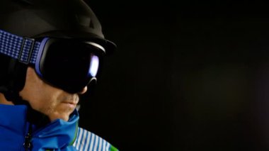 Siyah arka plan üzerine gözlüklü kayakçı/snowboard adam portresi yarım yüz
