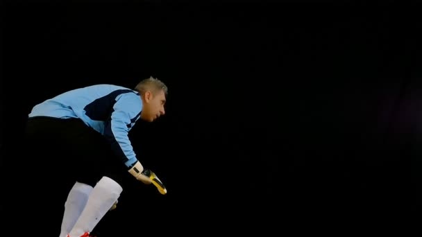 Futbol kaleci siyah arka plan üzerine atlama — Stok video