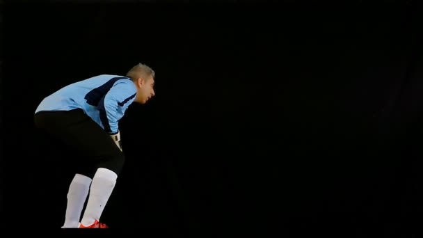 Fútbol portero de fútbol saltando sobre fondo negro — Vídeo de stock