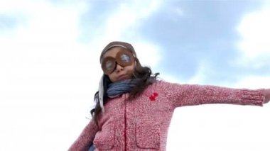 Pilot şapkası silah yayılan oynarken küçük kız gibi bir uçak mavi gökyüzü, ağır çekim