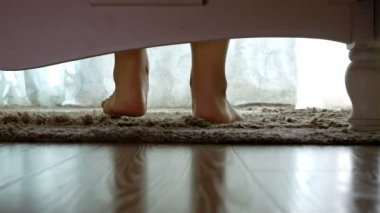 Sabah, kamera yatağın altında temas yatağın ayak dışarı getting kadın