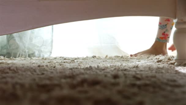 Χαριτωμένο μικρό κορίτσι ψάχνει για κάτι κάτω από το κρεβάτι, 4k — Αρχείο Βίντεο