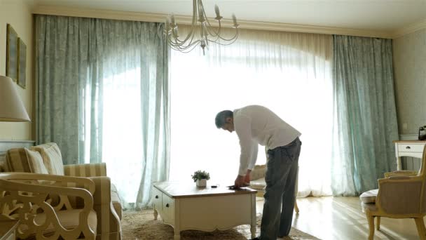 Uomo che torna a casa a rivedere le bollette e i pacchi della famiglia sul tavolo — Video Stock