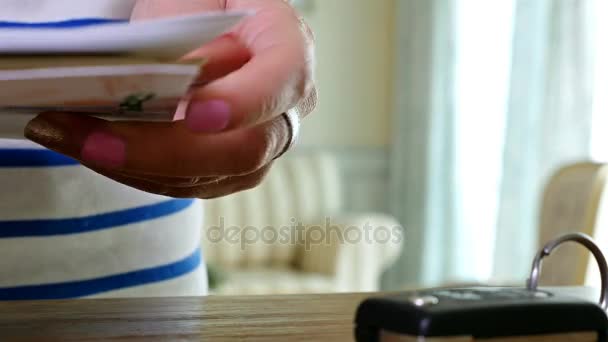 Mujer poniendo las llaves del coche en la mesa revisando las facturas del hogar — Vídeos de Stock