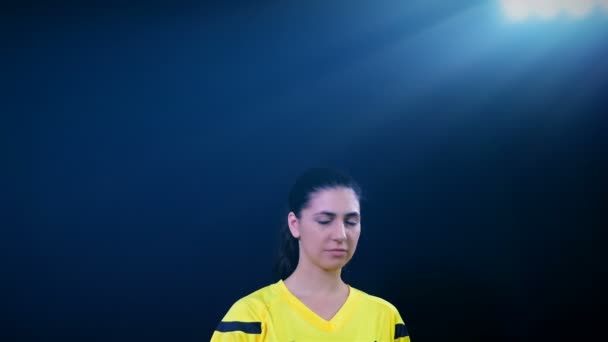 Nő Labdarúgás nemzetközi labdarúgó-játékvezető mutatja büntetés sárga kártyát a fekete háttér, 4k — Stock videók