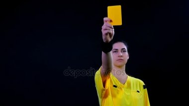 Ceza daha kırmızı kart sarı gösterilen ve kapalı gönderme oyuncu siyah arka plan üzerine, ağır çekim kadın futbol futbol hakemi