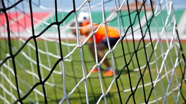 Movimento lento de treinamento de jogadores de futebol, rede de futebol na frente — Vídeo de Stock