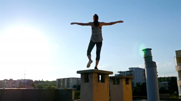 年轻女子正在做瑜伽姿势的屋顶上的建筑 健康的生活方式 — 图库视频影像