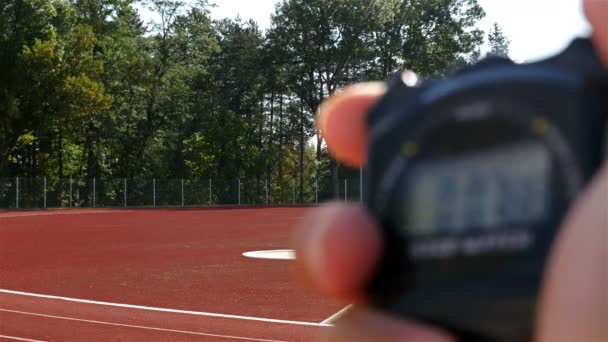 Θολή Χρονόμετρο Στο Χέρι Και Θηλυκά Αθλητής Δρομέας Στο Γήπεδο — Αρχείο Βίντεο