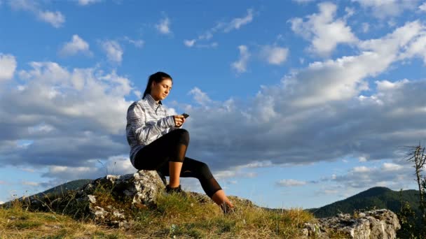 女性ハイカー女の子休暇旅行の冒険 を楽しむサンセット風光明媚な自然風景に山の上に携帯電話で入力 — ストック動画