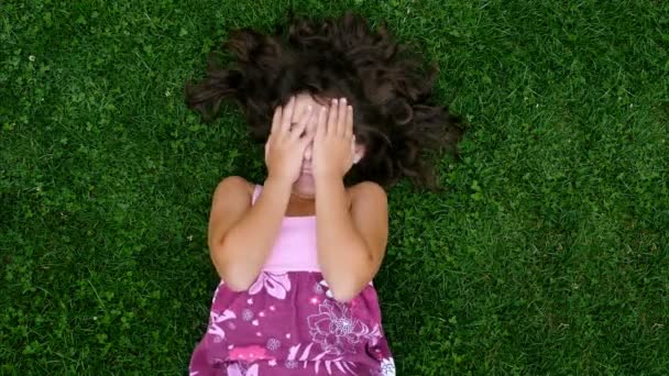 Sorridente Bambina Sdraiata Sull Erba Con Capelli Divaricati Nascondendo Viso — Video Stock