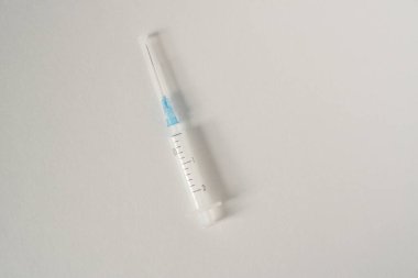 Tarafsız bir arkaplanda beyaz küçük şırınga