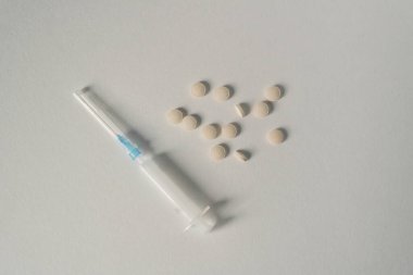 Nötr bir zemin üzerinde vitaminli küçük beyaz şırınga