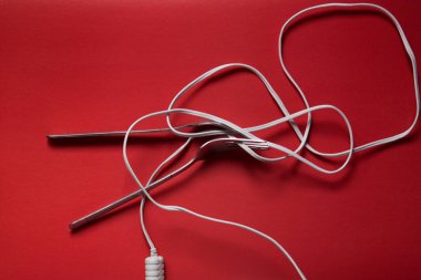 Demir çatallar kırmızı bir zeminde erişte yerine tel ile