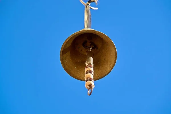 Free hanging bell photographed from below with a blue sky — Stock Photo, Image