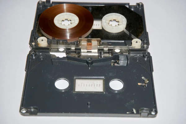a screwed on audio cassette tape against a white background