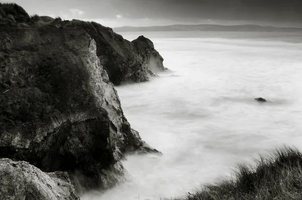 Gwithian beach, Cornwall, İngiltere'de Kuzey uçurum karşı çökmesini dalgaları güzel uzun pozlama