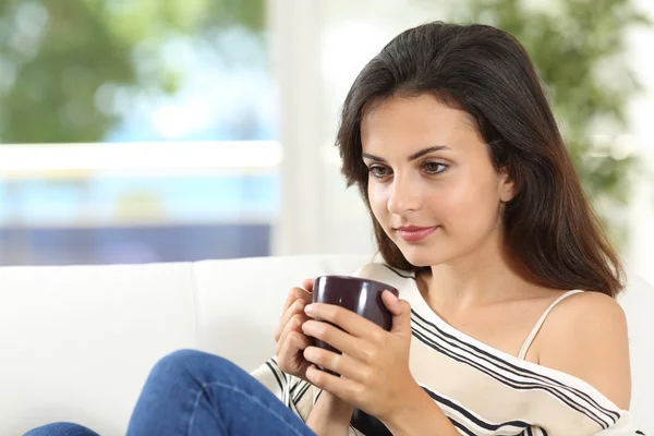 Mujer pensando con una taza de café en casa —  Fotos de Stock