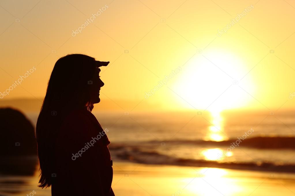 Silhueta de mulher triste preocupado ao pôr do sol