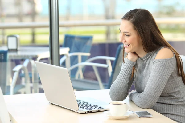 Woman enjoying media in a laptop — Stock Photo, Image