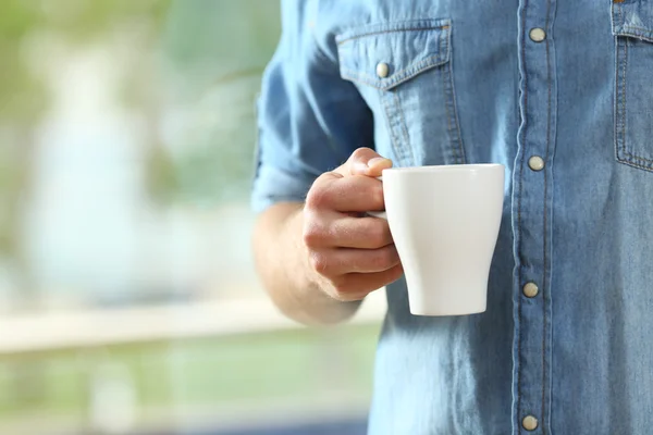 Mão de homem segurando uma xícara de café — Fotografia de Stock