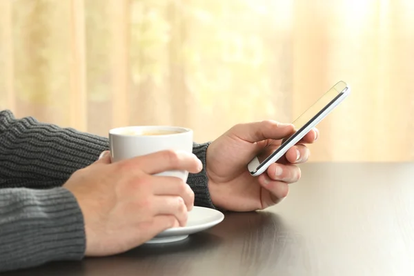 Ruce držící kávy a pomocí chytrého telefonu — Stock fotografie