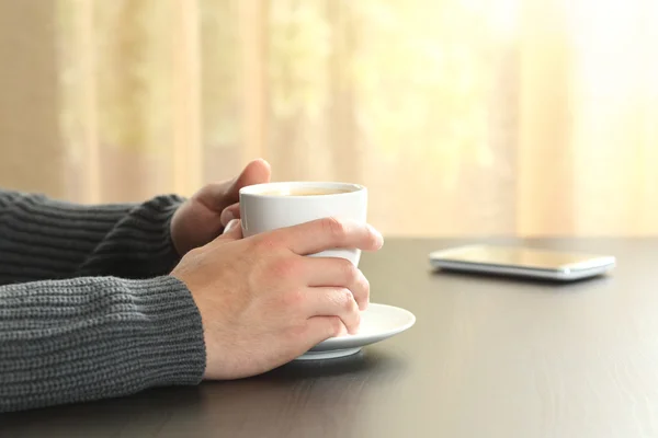 Mann hält entspannt eine Tasse Kaffee in den Händen — Stockfoto