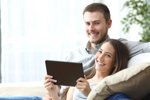 Couple with tablet posing at home