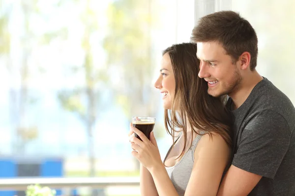 Pareja feliz o matrimonio mirando por la ventana — Foto de Stock