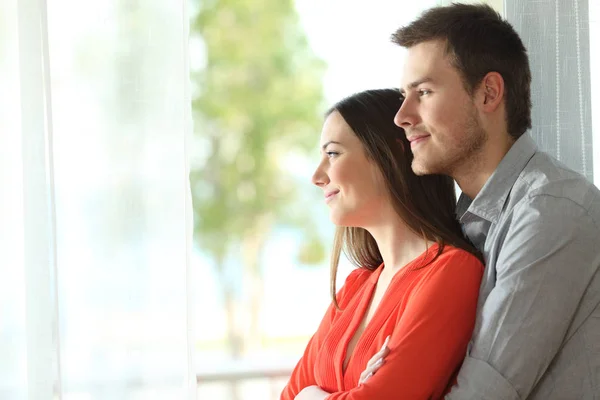 Matrimonio guardando attraverso una finestra a casa — Foto Stock