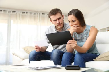 Worried couple checking bank account online clipart
