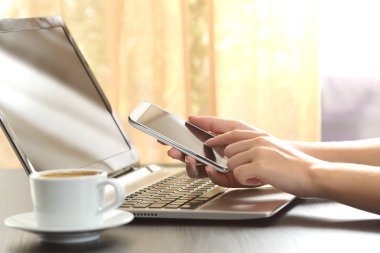 Bir akıllı telefon ve dizüstü kullanarak kız eller