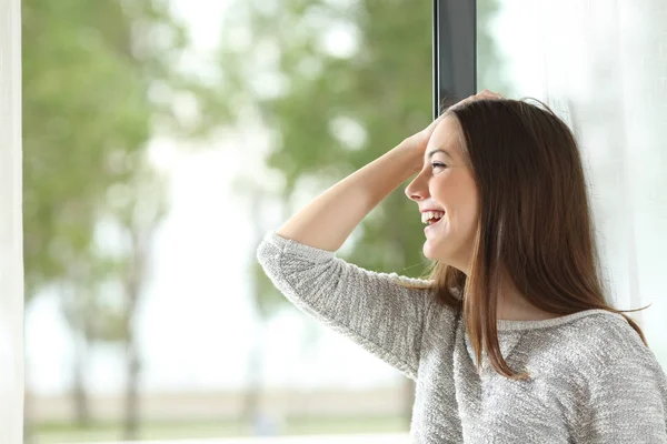 Chica riendo y mirando a través de la ventana —  Fotos de Stock