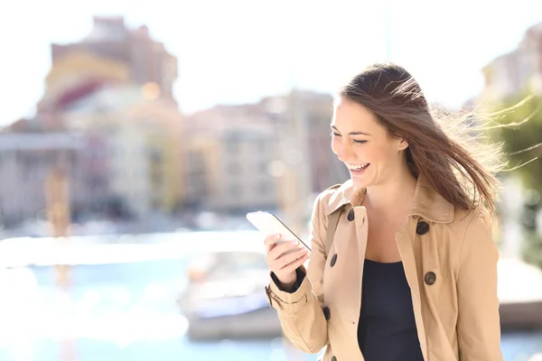 Femme heureuse riant regarder le téléphone — Photo