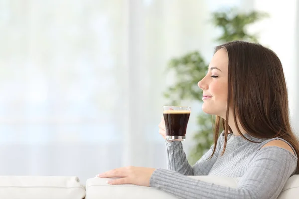 Vrouw ruiken een kopje koffie thuis — Stockfoto
