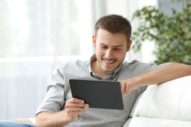 Adam evde bir kanepede tablet kullanma