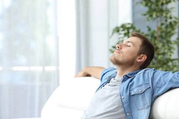 Man resting on a couch at home — Stock Photo, Image