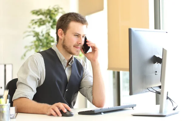 Empresário chamando pelo telefone e usando um computador — Fotografia de Stock