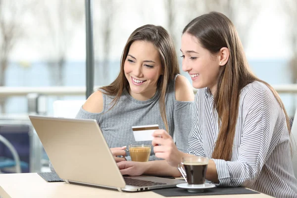 Dois amigos comprando on-line com um laptop — Fotografia de Stock