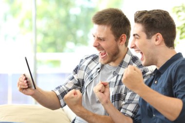 Bir tablet üzerinde TV izlerken heyecan arkadaşlar