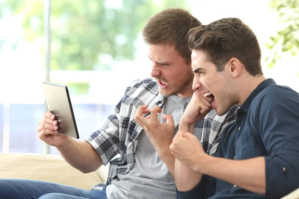 Amigos enojados viendo los medios en una tableta — Foto de Stock